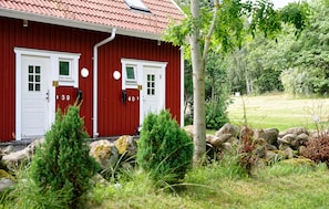 Un bâtiment rouge avec deux portes blanches, chacune portant un numéro.