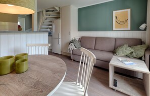 Ein modernes Wohnzimmer mit einem runden Holztisch, einer Couch und einem kleinen Couchtisch.