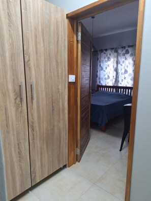 A room with a wardrobe, a bed, and a curtain. - One Bedroom apartment with access to swimming pool (Beau Bassin-Rose Hill)