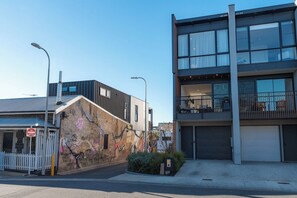 Ein modernes Gebäude mit Garage, weißem Zaun und Straßenlaterne.