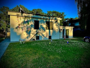 A modern building with a flat roof, large windows, and a small front yard with grass and a few trees. - Stylish Lakefront Studio in Caputh with Lake Access & Garden (Schwielowsee)
