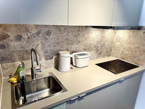 A kitchen with a stainless steel sink, a toaster, and a coffee maker. - Stylish Lakefront Studio in Caputh with Lake Access & Garden (Schwielowsee)