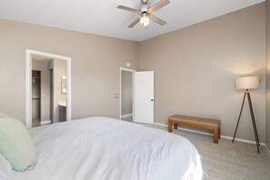 A bedroom with a bed, a bench, a floor lamp, a ceiling fan, and a door leading to a closet. - 3BR Phoenix Retreat Near Golf & Water Parks (Phoenix)