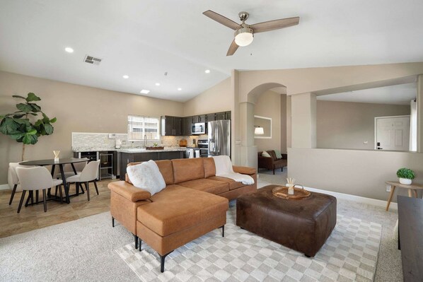 A modern living room with a sofa, ottoman, and dining area. - 3BR Phoenix Retreat Near Golf & Water Parks (Phoenix)