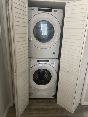 Un lavadero pequeño y funcional con lavadora y secadora integradas.