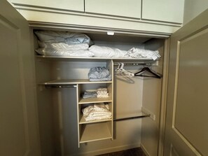 A walk-in closet with shelves, a hanging rod, and a folded bed. - NEW Enjoyable 2-bedroom townhome in Twin Falls (Twin Falls)
