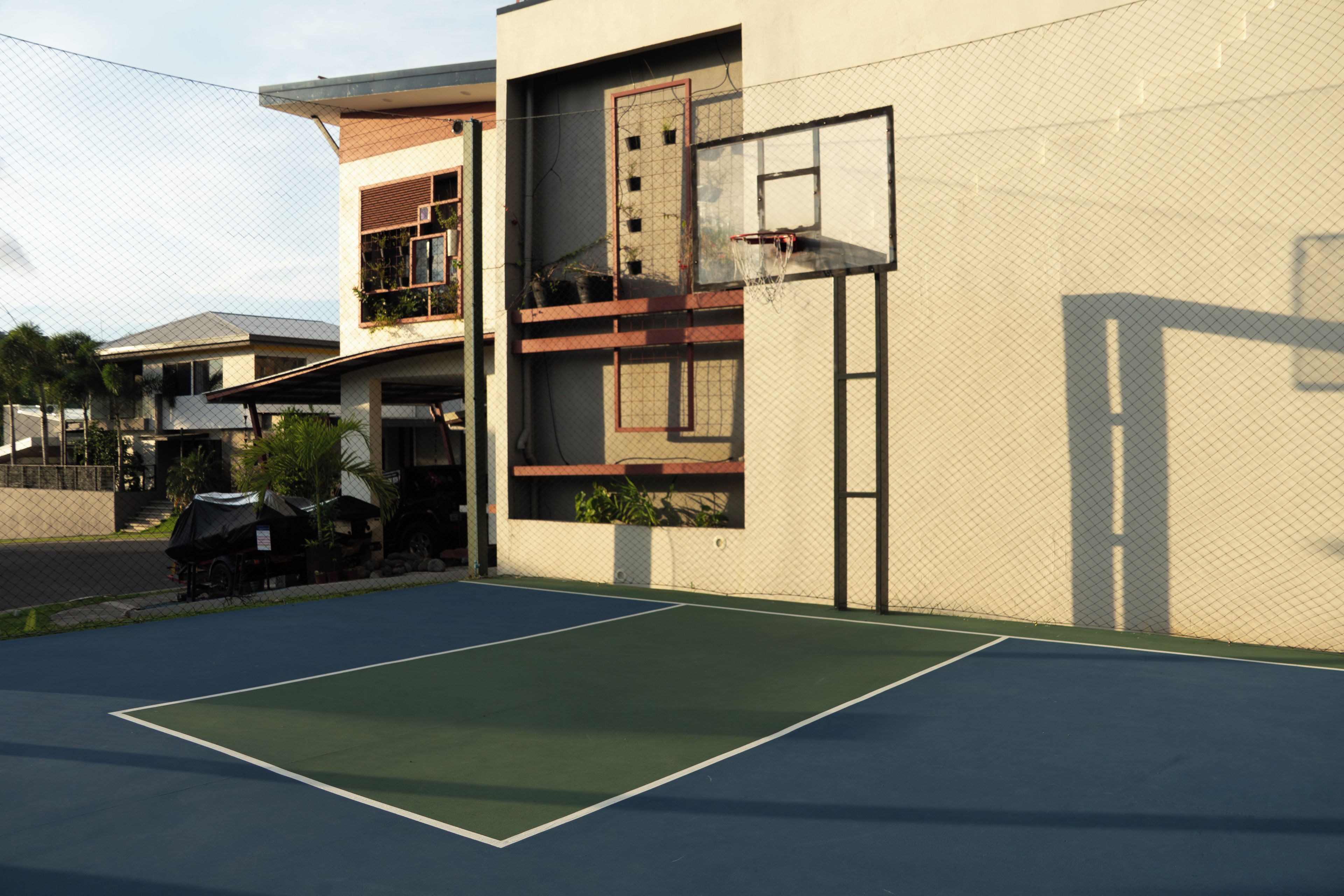 Quadra de basquete ao lado de um edifício com cesta.