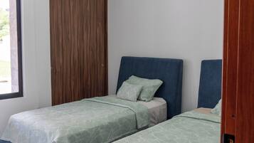Une chambre avec deux lits, un ventilateur de plafond et un appareil de climatisation.