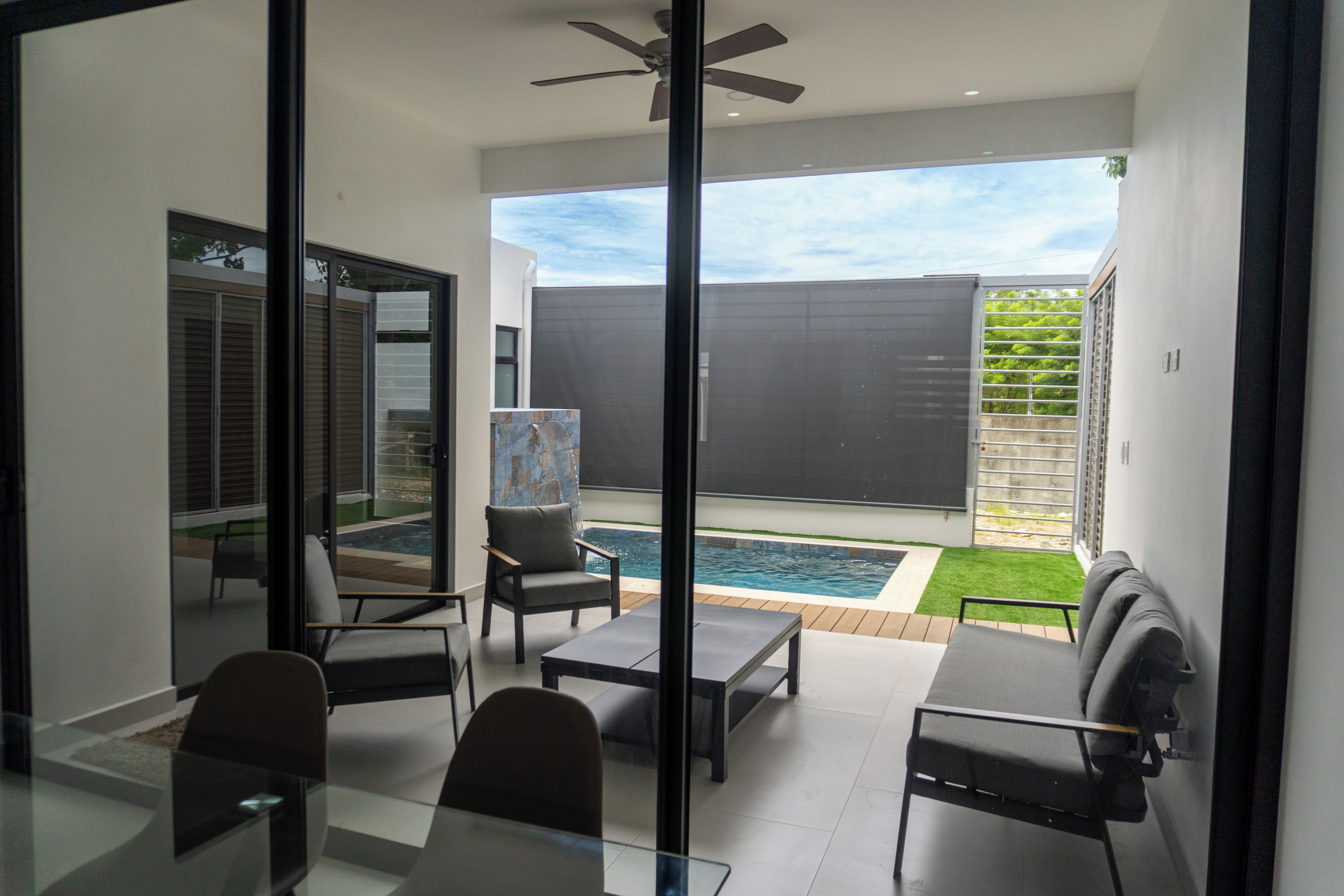 A modern interior with a glass door leading to a pool area.