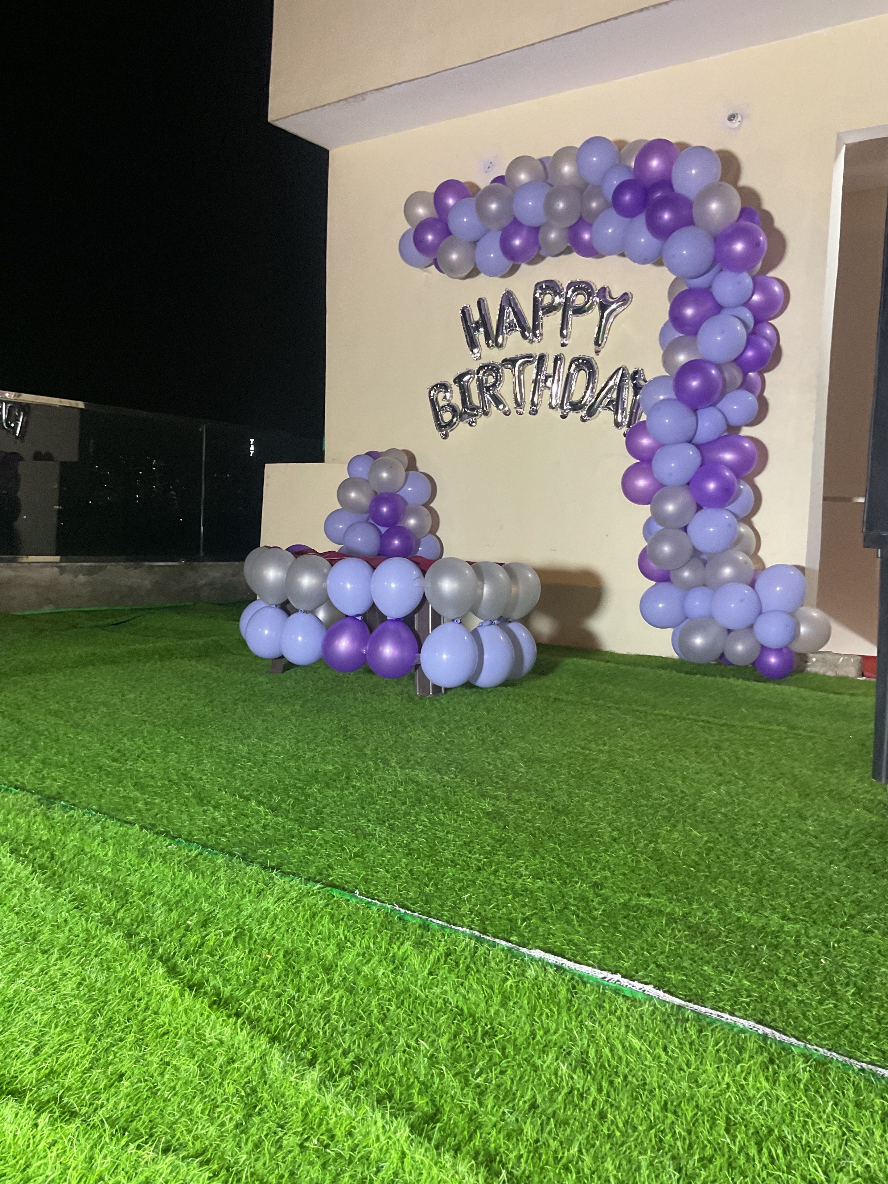 A birthday decoration with balloons and a 'Happy Birthday' sign.