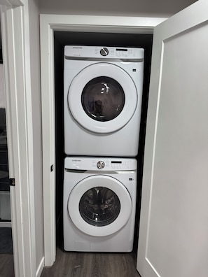 Une buanderie équipée de deux machines à laver à chargement frontal superposées.