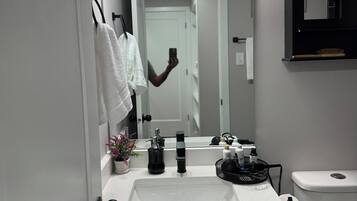A bathroom with a white sink, black faucet, and a mirror above it.