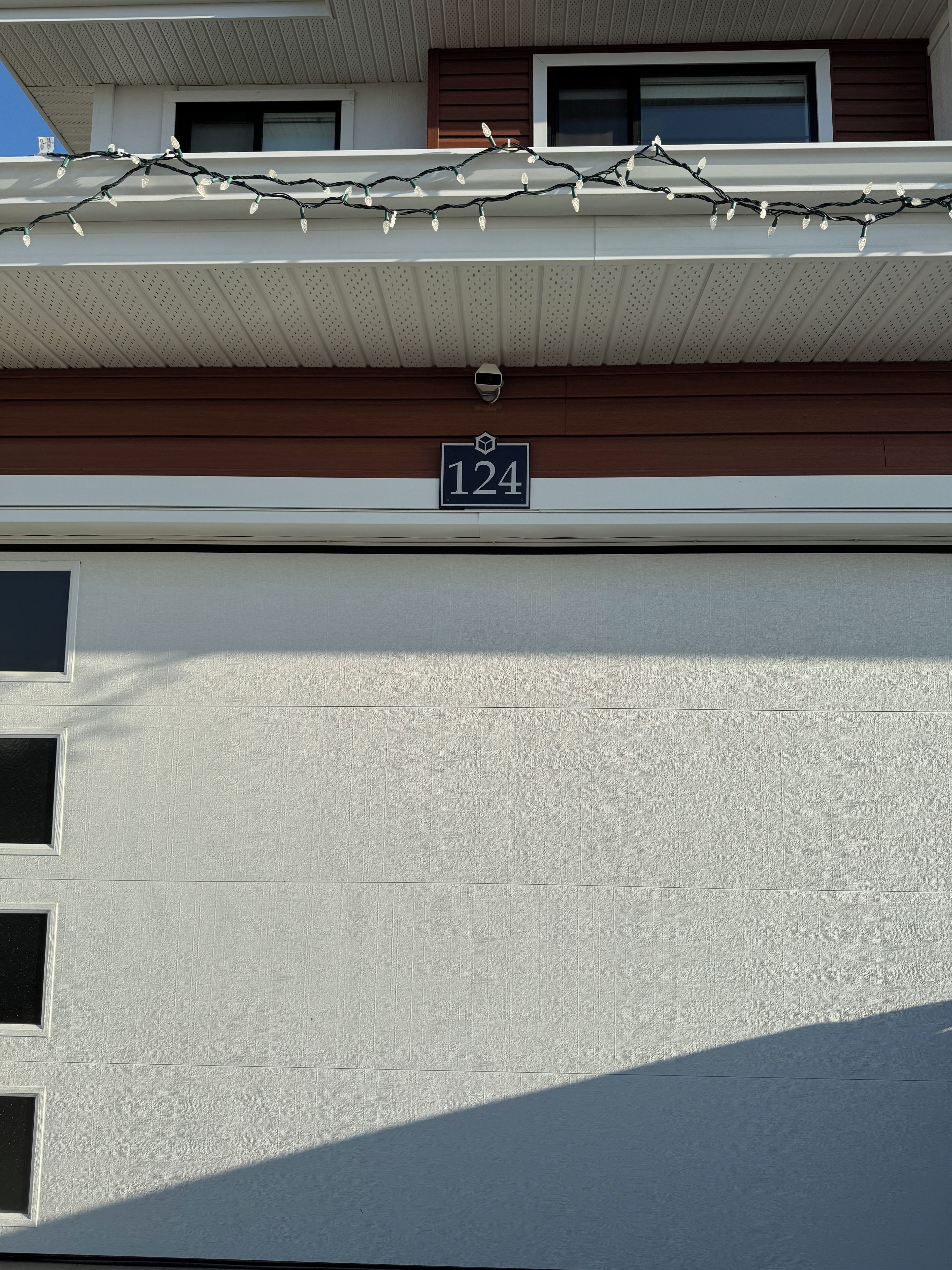Une façade d’immeuble ornée d’un numéro « 124 » et d’une guirlande lumineuse.
