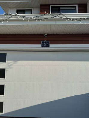Une façade d’immeuble ornée d’un numéro « 124 » et d’une guirlande lumineuse.