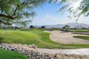 Un parcours de golf doté d’un gazon bien entretenu, de bunkers de sable et offrant une vue dégagée sur les montagnes lointaines.