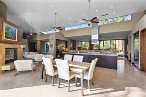 A spacious kitchen with a large island, modern appliances, and a view of the outdoors. - Stunning 9 Bedroom Golf Estate - 200 Feet Golf Frontage on Private Course (Rancho Mirage)