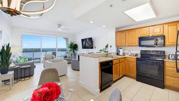 A modern kitchen with a central island, wooden cabinets, and stainless steel appliances.