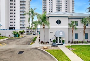A modern building with a flat roof, a large circular window, and a sign for 'Blue Heron'. - 12 Floors Up with King, Bunks and Resort Pool (Orlando)