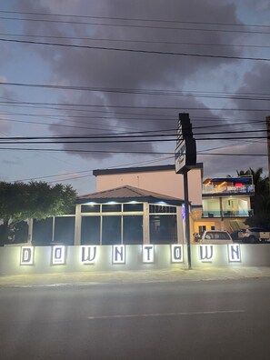 A building with a sign that reads 'DOWNTOWN' and a street sign above it.
