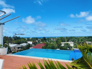 A swimming pool with a view of the ocean and surrounding buildings. - Hotel Down Town Cabrera (Cabrera)