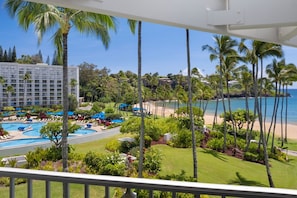 Ein Resort mit Poolbereich, Strand und Palmen.