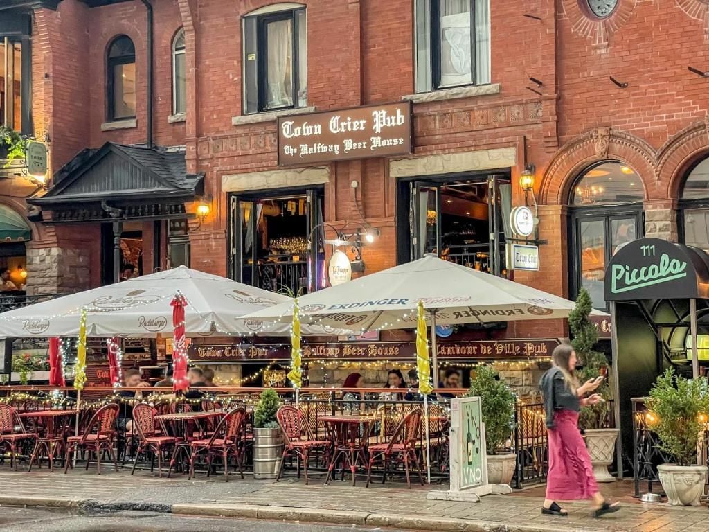 A pub with outdoor seating and a brick facade.