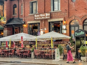 A pub with outdoor seating and a brick facade. - Nova The Entertainment District Toronto (Toronto)