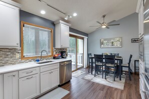 Una cocina moderna con lavavajillas, estación de café y comedor con mesa y sillas.