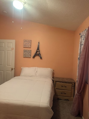 A bedroom with a bed, a nightstand, a dresser, a door, and wall decorations including a large Eiffel Tower and two signs with text. - Fantastic 5-bedroom family house with AC in vibrant Albuquerque (Albuquerque)