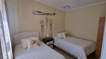 Un dormitorio con dos camas, una mesita de noche y decoración en la pared.