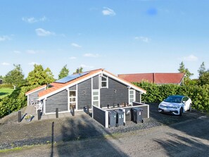 A modern building with a sloped roof, solar panels, and a car parked in front. - "Nelia" - 1km from the sea by Interhome (Væggerløse)