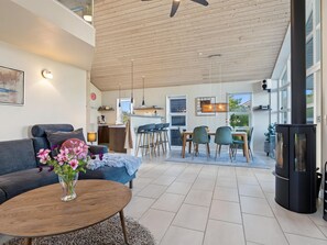 Un salon moderne avec un canapé, une table basse et un coin repas avec des chaises.