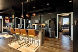 A modern kitchen with a central island, stainless steel appliances, and pendant lighting. - Family Reunion Ranch Near Zion: 4 Homes, Sleeps 26 (Kanab)
