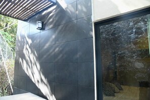 A modern building exterior with a tiled wall and a glass door leading to an interior space. - Cuernavaca Downtown Golf Club Boutique House with a heated pool (Cuernavaca)