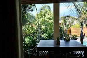 A wooden table with a framed picture, surrounded by lush greenery and a wooden fence. - Cuernavaca Downtown Golf Club Boutique House with a heated pool (Cuernavaca)