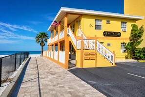 Un edificio amarillo con un letrero que dice 'Misty Isles' y una escalera que lleva a un balcón.