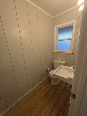 Un baño con inodoro, lavabo y ventana.
