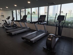 A gym with treadmills, stationary bikes, and exercise equipment. - Luxury Waterfront 1BR Steps to Cleveland, Galleria and ADGM By Betu (Abu Dhabi)