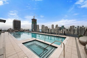 A rooftop pool with a city skyline view, including a building under construction. - 501 First Loft Balcony by Palermo Home (Miami)