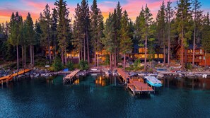 A lakeside property with multiple buildings, docked boats, and a wooden walkway. - Meeks Bay Chalet by Avantstay Lakefront Retreat Boat Dock + Hot Tub Near Beach (Tahoma)