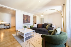 Ein modernes Wohnzimmer mit einer Couch, einem Couchtisch und einer Stehlampe.