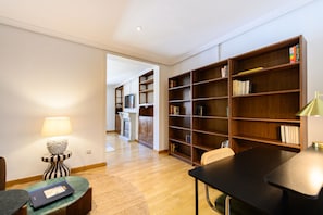 Une pièce comprenant une table à manger, des chaises, une bibliothèque et une cheminée.