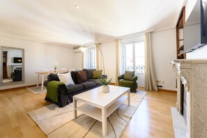 A living room with a sofa, a coffee table, a TV, and a fireplace. - M Fer55d Amplio Piso 3 Dormitorios en Moncloa (Madrid)