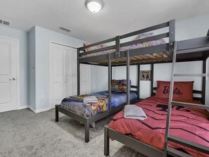 A bunk bed room with a door and a poster on the wall. - Family Townhouse Near Disney | HeatedPool | Lazy River (Kissimmee)