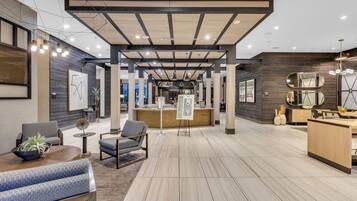 A modern interior with a reception desk, seating area, and a wooden floor.