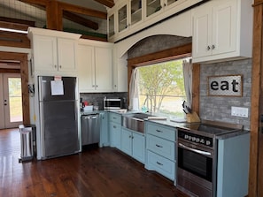 A kitchen with a stainless steel refrigerator, a microwave, a dishwasher, and a built-in oven. - The Cabin With The OK View (Grayson County)