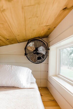 A bedroom with a bed, a window, and a ceiling fan. - Texas Tiny Cabins #2 – Peaceful Cabin, Scenic View (Grayson County)