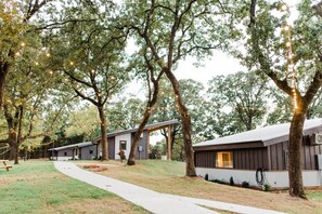 A property with multiple cabins, a paved walkway, and trees. - Texas Tiny Cabins #2 – Peaceful Cabin, Scenic View (Grayson County)