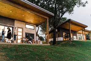 Um edifício moderno com área de estar coberta ao ar livre e um gramado.