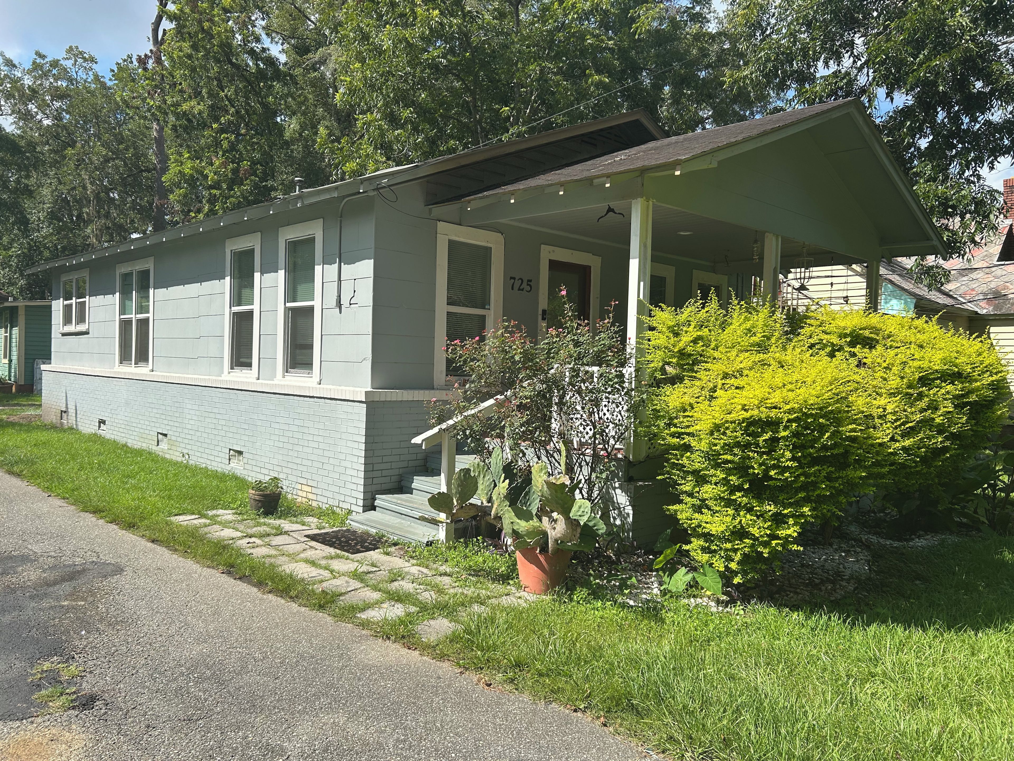 A single-story house with a porch, a small front yard, and a mailbox.